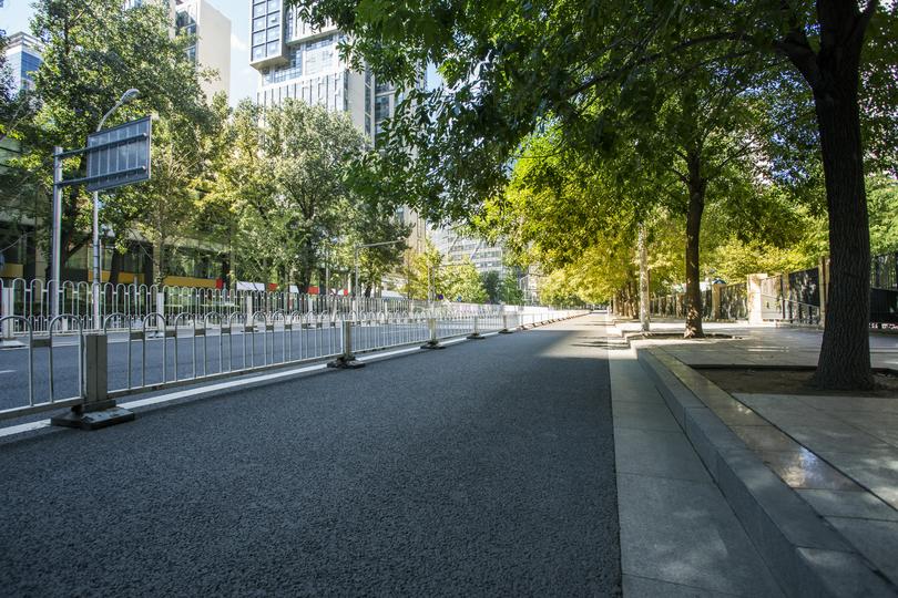 A winding concrete footpath in a park setting