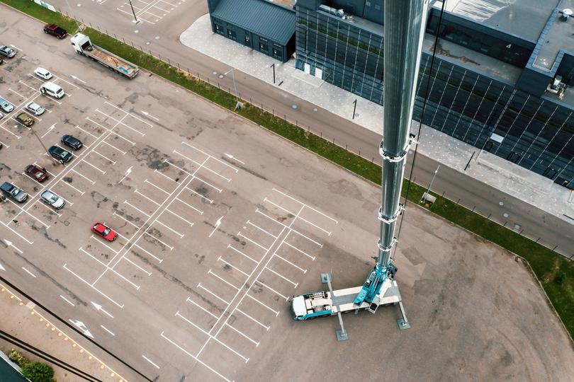 A Boom pump extending its arm to pour concrete on a high-rise building