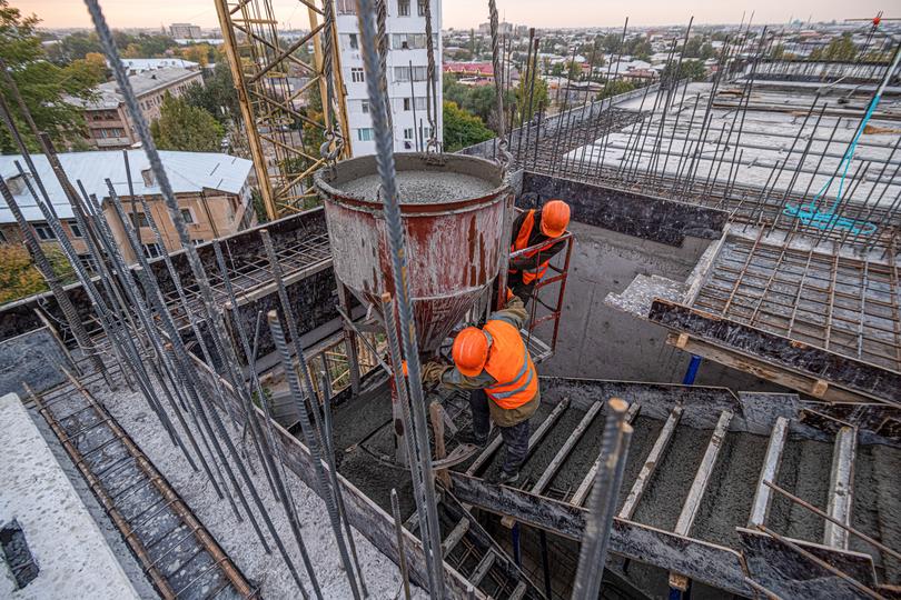 A high-rise building under construction with concrete being poured